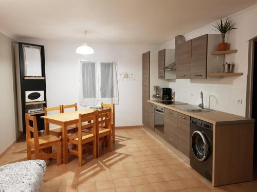 a kitchen and dining room with a table and chairs at Les Gîtes de l'Arbousier in Quissac