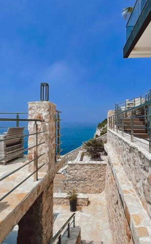 a stone wall with a view of the ocean at Apart Lux Beciragic in Dobra Voda