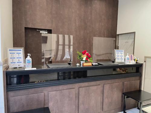 a reception desk with a glass counter top with flowers at Ueno Urban Hotel Annex in Tokyo