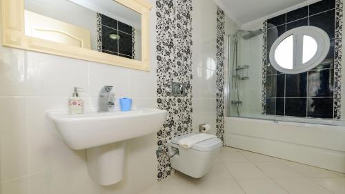 a bathroom with a sink and a toilet and a mirror at Musa - 5 Bedroom Holiday Villa in Hisaronu in Fethiye