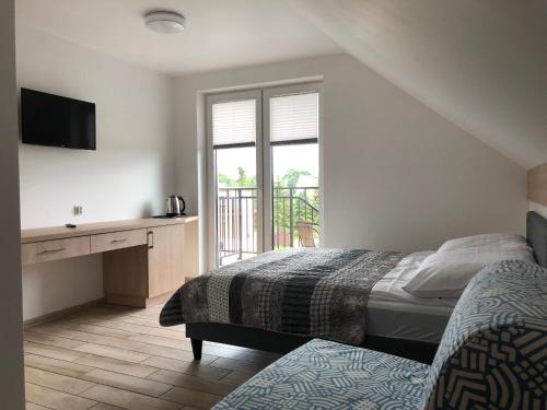 sypialnia z 2 łóżkami, biurkiem i oknem w obiekcie Pokoje nad Morzem w Sztutowie