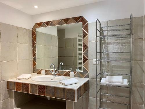 a bathroom with a sink and a mirror at Chambres d'hôtes et studios de charme - A Mandria in Murato
