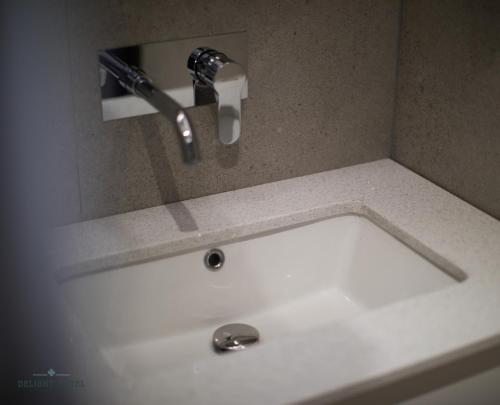 a white sink with a faucet in a bathroom at Delight Hotel in Ksamil