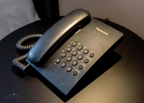 a black phone sitting on top of a table at Delight Hotel in Ksamil