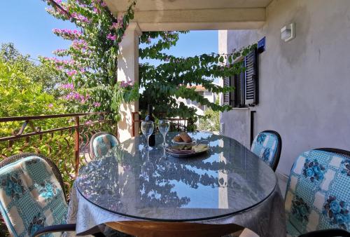 einen Glastisch und Stühle auf dem Balkon in der Unterkunft Apartment Adriana in Seget Vranjica