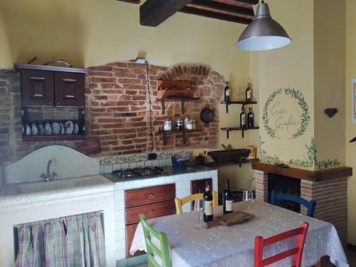 uma cozinha com uma mesa e uma parede de tijolos em Casa Giulia on Francigena em Gambassi Terme