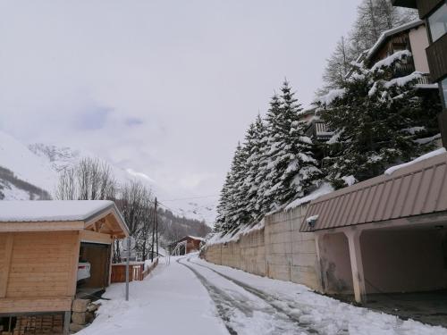 a snow covered street next to a building at Appartement 8 couchages 45 m2 tout confort à la foux d'allos in La Foux