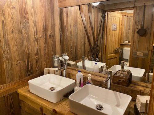 a bathroom with two sinks and a large mirror at Hotel Le Clou in Arvier
