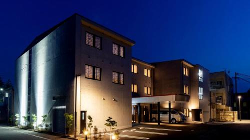 a building with a car parked in front of it at night at Hotel Rosso Karuizawa in Karuizawa