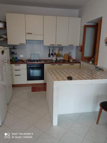 a kitchen with white cabinets and a counter top at MareLuna in Pioppi