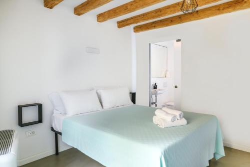 een witte slaapkamer met een bed en een spiegel bij M9 Rooms in Izola