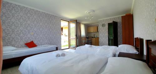 a bedroom with two beds with white sheets at Oda Kazbegi in Stepantsminda
