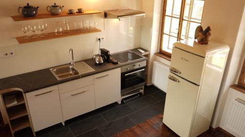 a kitchen with a white refrigerator and a sink at Baroque chaplain house Kaplanka 1796 A. D. - historical luxury apts in Bohemian Paradise in Železný Brod