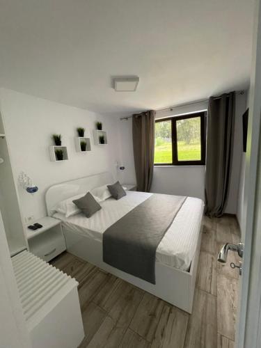 Un dormitorio blanco con una cama grande y una ventana en Aruba, en Jupiter
