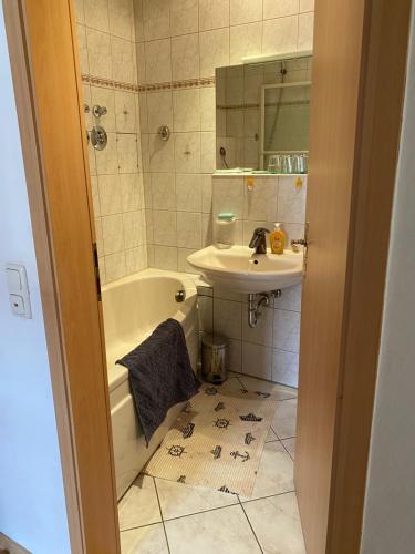 a bathroom with a sink and a tub and a mirror at Ferienwohnung am Stadtgraben in Wilsdruff