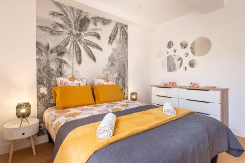 une chambre avec un grand lit avec une couverture jaune dans l'établissement JJ8 - MAGNIFIQUE 3PIECES, ENTIEREMENT RENOVE, CLIM, VIEUX-NICE, à Nice