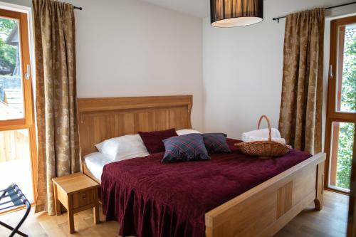 een slaapkamer met een bed met een paarse sprei bij Apartments Vila Jelka in Bohinj