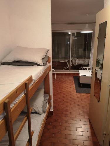 - une chambre avec 2 lits superposés et un salon dans l'établissement Studio climatisé Centre Port Piscine, au Cap d'Agde