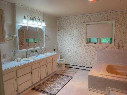 y baño con 2 lavabos, bañera y aseo. en Spacious Resort Style Retreat Sleeps 20 en Fairbanks