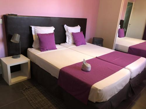 a bedroom with two beds with purple and white pillows at Villa Natur Dylis in Saint-François