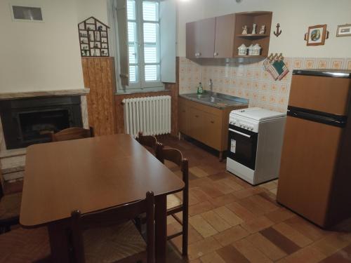 a kitchen with a table and a stove and a refrigerator at Casa Vacanze da Peppa in Grottazzolina