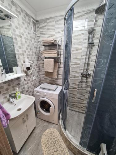 a bathroom with a shower and a washing machine at 2-х кім.квартира в центрі Берегова in Berehove