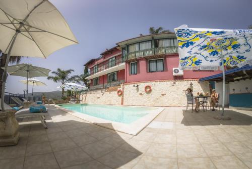 a hotel with a swimming pool and a building at Alcantara Natura Country House in Graniti