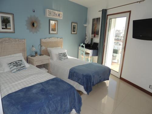 a bedroom with two beds and a sliding glass door at Marina-M in Lagos