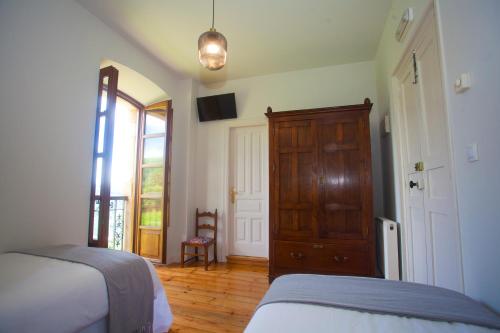 a bedroom with a bed and a dresser and a door at Casona de Indias in Piloña