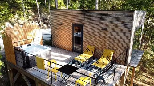 Cabaña pequeña con sillas amarillas en una terraza en La Parenthèse en Dieulefit