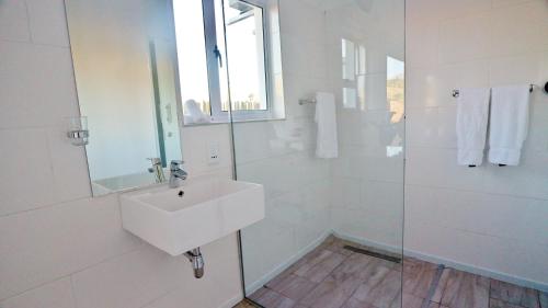 a white bathroom with a sink and a shower at theLAB Robertson in Robertson