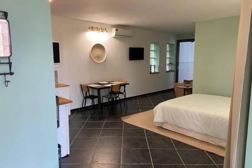 Schlafzimmer mit einem Bett und einem Tisch mit Stühlen in der Unterkunft Superbe studio privée au calme avec piscine et spa in Sailly-lès-Lannoy