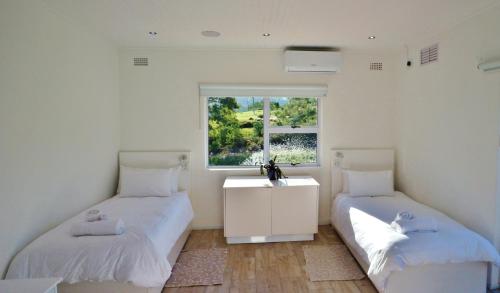 two beds in a room with a window at theLAB Robertson in Robertson