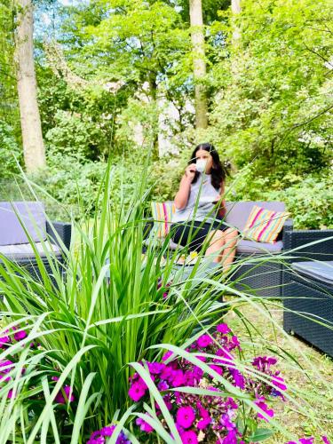 a woman talking on a cell phone in a garden at Hotel Carolinenhof in Berlin