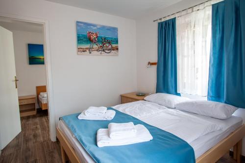 a bedroom with a bed with towels on it at Arcobaleno Apartments in Piran