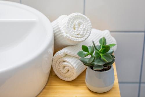 a towel and a plant on a table next to a toilet at Hotel garni Weberhäusl in Strobl
