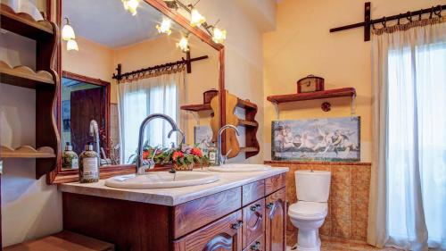 a bathroom with a sink and a toilet and a mirror at Classical Villa Anta in Agios Ioannis
