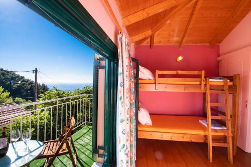 a room with a balcony with bunk beds at Lefkada Sunset House in Kalamitsi