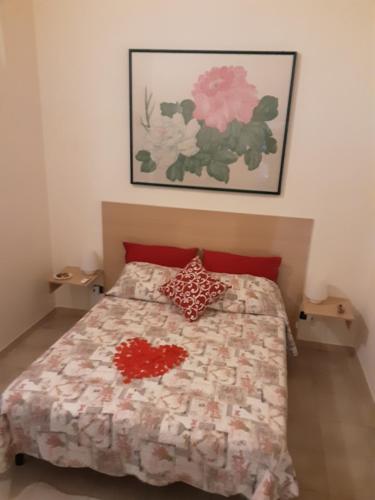 a bedroom with a bed with two red pillows at B&B Emily Brindisi in Brindisi