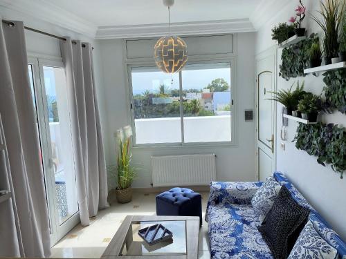 a living room with a blue couch and a glass table at Roof Top Pied dans l'Eau Panoramic View, 80 meters from Seaside in Hammamet