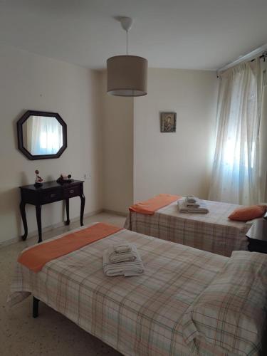 two beds in a room with a mirror and a table at EL PUERTO CENTRO OCIO in El Puerto de Santa María