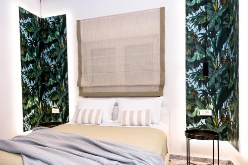 a bedroom with a bed with a window and plants at NK Apartments in Falasarna