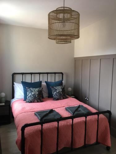 a bedroom with a large bed with a red blanket at Shoemakers Cottage in Ramsgate