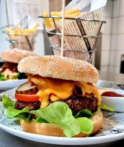 a cheeseburger with cheese and lettuce on a plate at Best Western Hotel Rosenau in Bad Nauheim