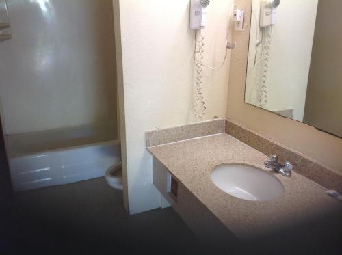 a bathroom with a sink and a mirror and a toilet at Summit Inn - Dayton in Dayton