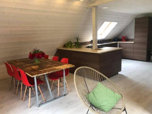 una cucina con tavolo in legno e sedie rosse di Gîtes du Tichweg a Colmar