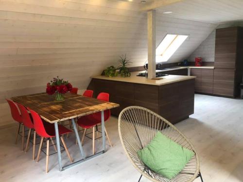 a kitchen with a wooden table and red chairs at Gîtes du Tichweg in Colmar