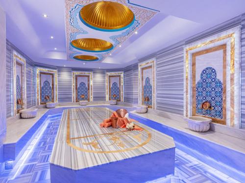 a room with a swimming pool with gold ceilings at Elysium Green Suites in Antalya