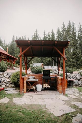 a wooden gazebo in a yard with a desk at Cabana Bucin in Bucsin