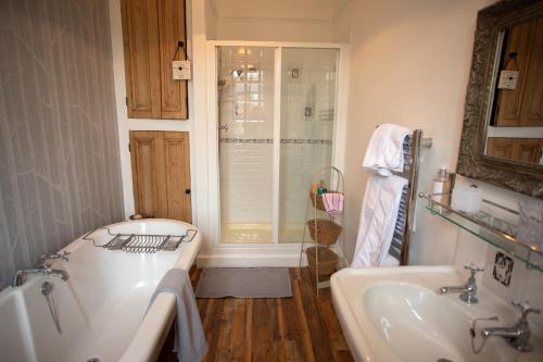 ein Badezimmer mit einer Badewanne und einem Waschbecken in der Unterkunft Treherne House & The Malvern Retreat in Great Malvern